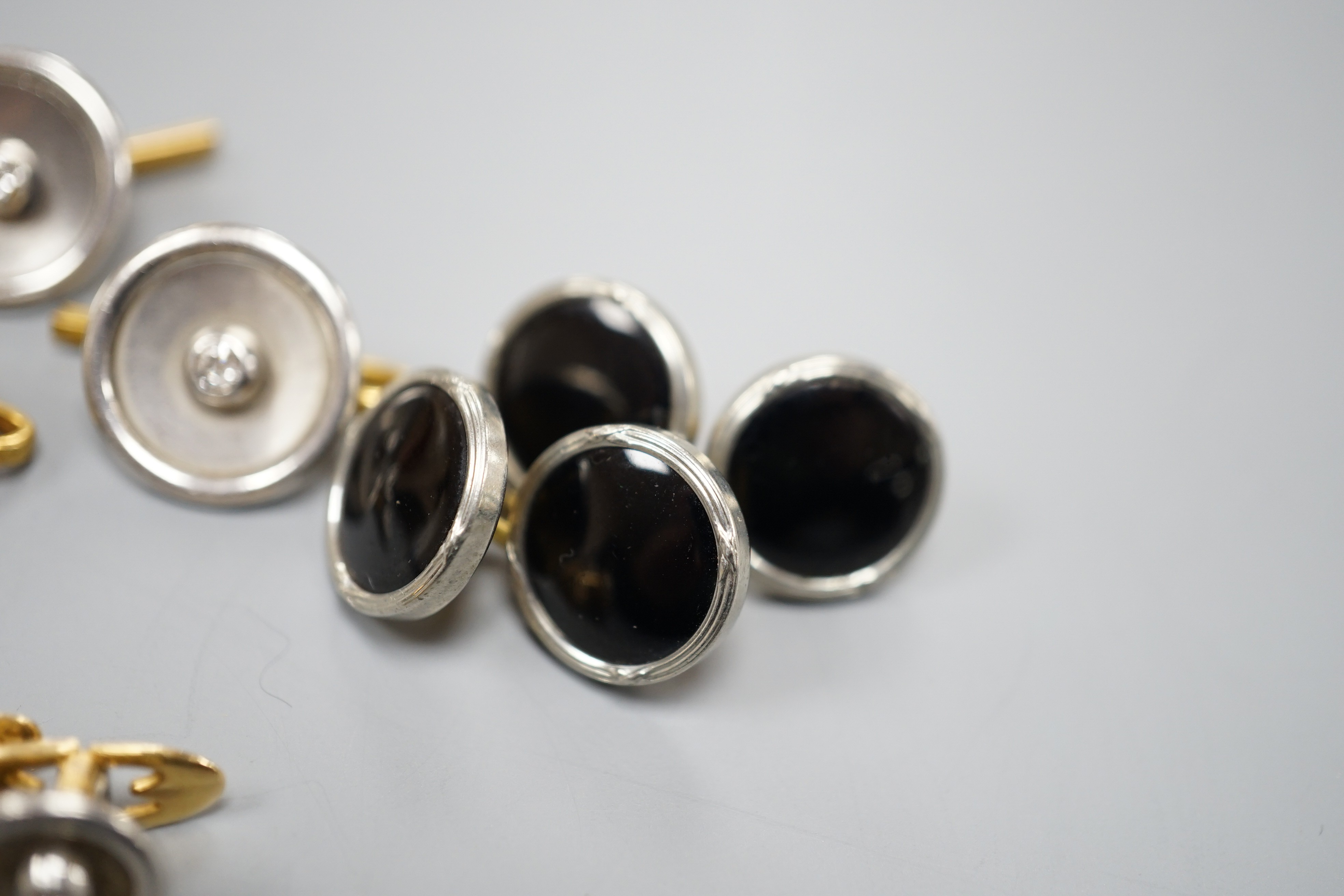 A pair of small pair of yellow and white metal diamond set cufflinks and four similar dress studs and four other yellow metal and black enamel? dress studs, gross weight 22.6 grams